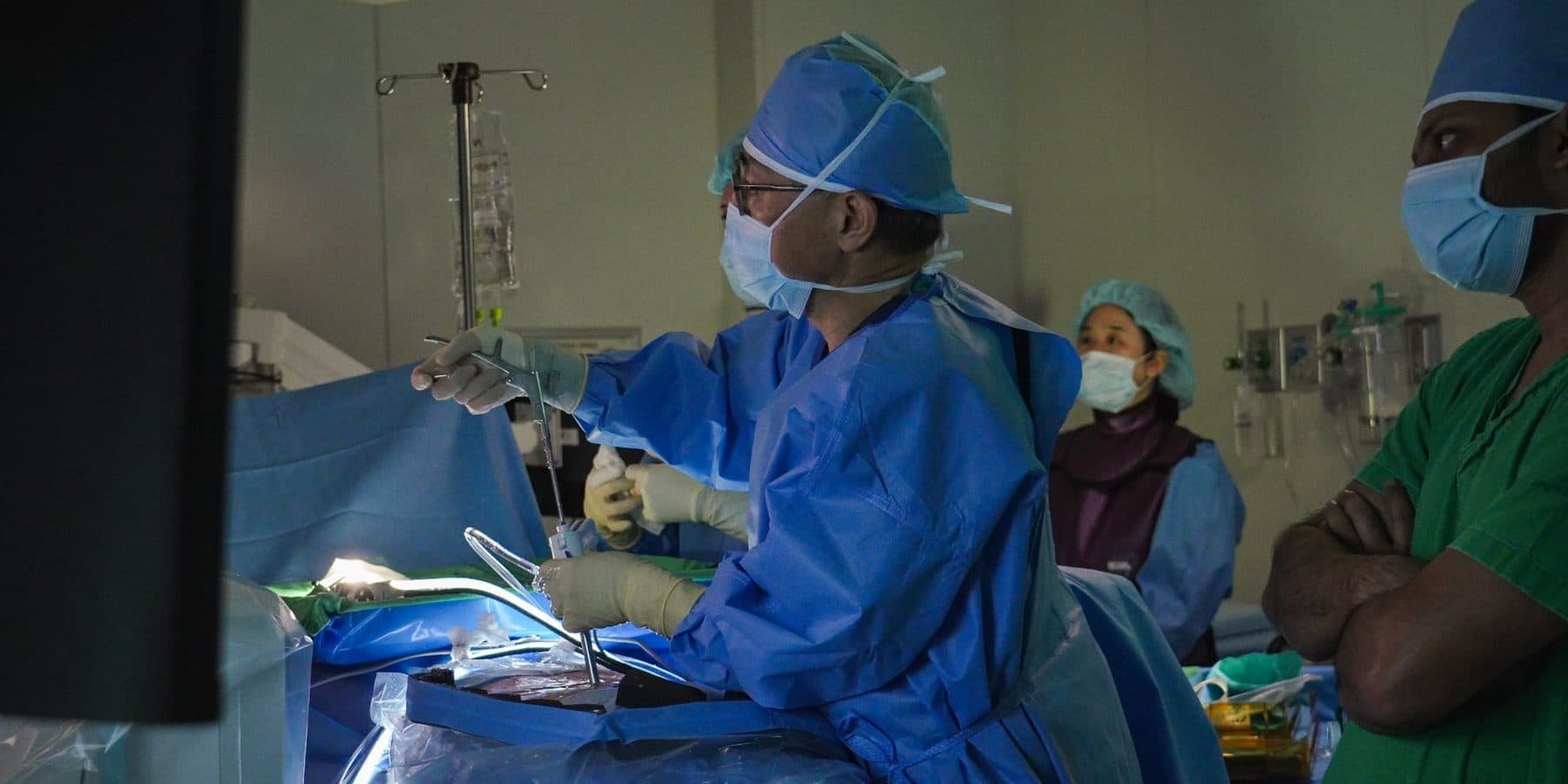 Surgeon operating with the TISE scope while colleagues observe at the table